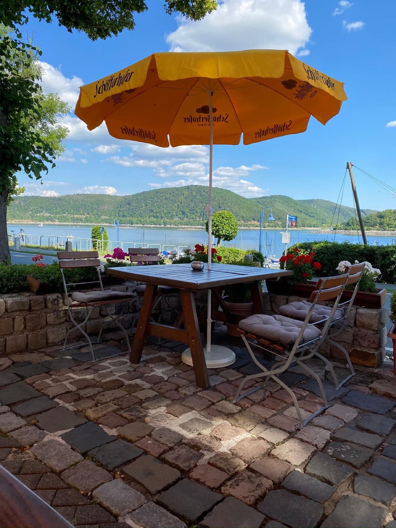 Sonnenschirm und Holztisch vor dem See